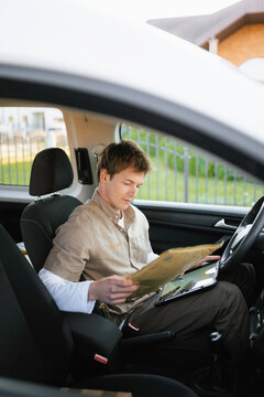 The postman uses a tablet sitting in the car