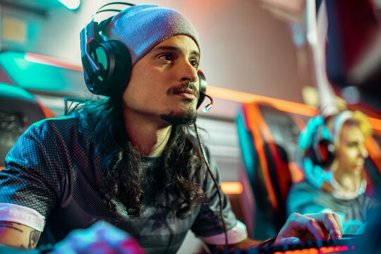 Young man gaming with headset in esports arena
