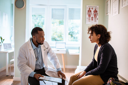 Doctor consulting patient in clinic exam room
