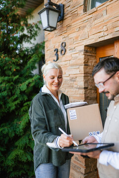 The postman delivers the parcel to the customer