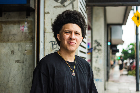 Man standing in the street squinting 