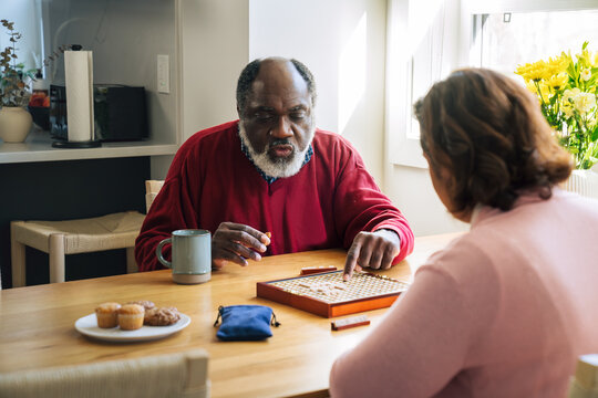 
Happy Multiracial Senior Couple Playing Scrabble Together at Home