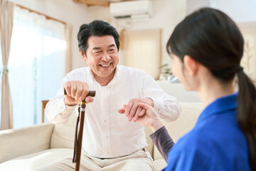 Obraz premium 訪問介護でシニアに手を差し伸べる介護士