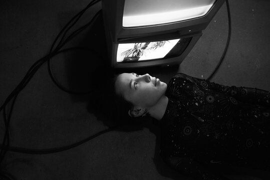 Woman lying close to old TV