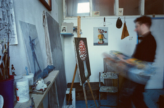 Blurred artist painting a oil canvas in his studio 