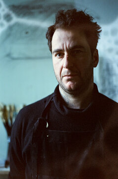 Portrait of Thoughtful Artist Dressed in Black in his Studio 