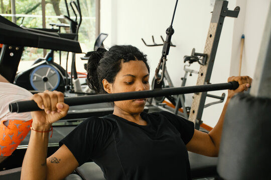 Black woman doing reps in a gym mahine
