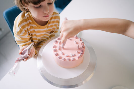 Children decorate the birthday cake