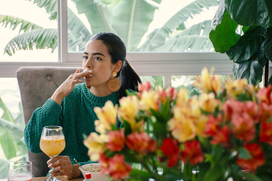 Latin woman licking her fingers at the table
