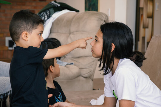 Little brother points sister's forehead