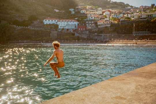 Man jumping into the ocean during vacation on Madeira island 