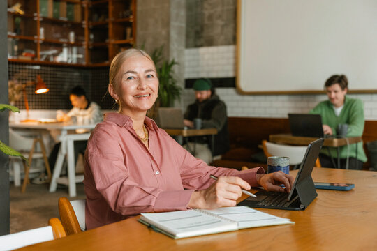 A woman works remotely sitting in a cafe