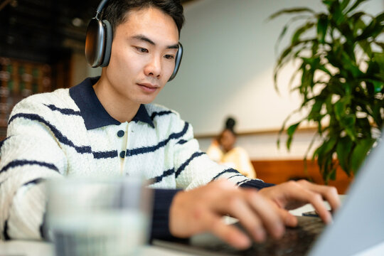 A man uses a laptop in a cafe