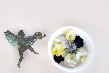 水に浮かべたパンジーと天使のカード