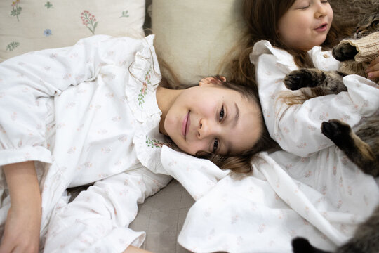 two girls are standing in dresses near the Christmas tree
