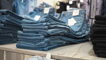 Denim jeans stacked on shelves in a clothing store