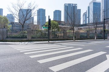 Urban street with zebra crossing and modern high-rise buildings in the background © zhu difeng