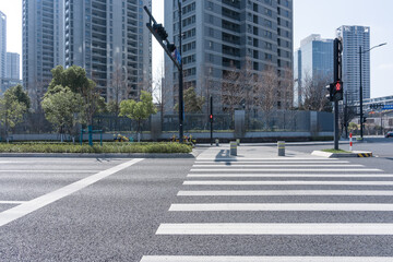 Urban street with zebra crossing and modern high-rise buildings under clear sunlight © zhu difeng