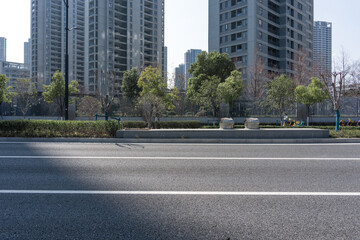 Obraz premium Urban road with high-rise residential buildings and greenery landscape on a sunny day