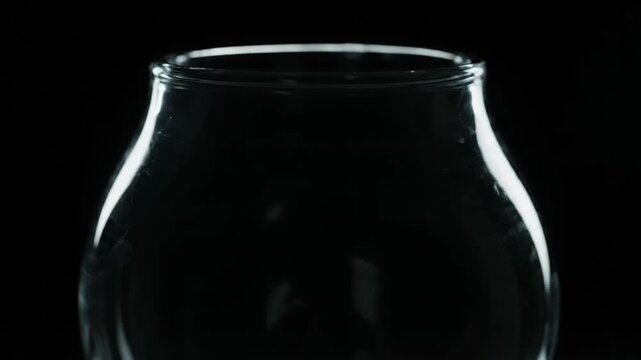 Close up of an empty glass against a black background.