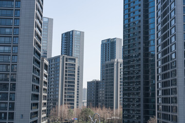 Obraz premium Modern high-rise residential buildings stand tall in a densely planned urban landscape under clear sky