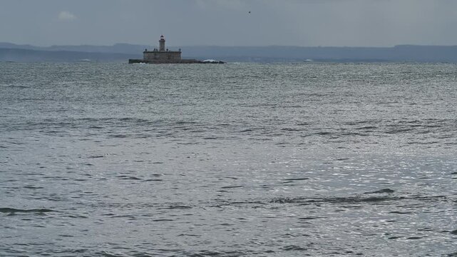 Bugio lighthouse centered on calm ocean horizon
