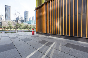 Modern urban plaza with wooden slat facade building and geometric pavement design © zhu difeng
