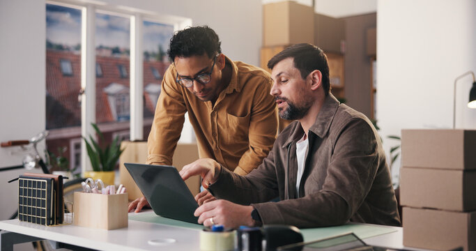 Logistics, review or men in office with laptop, order track or inventory management for shipping. Distribution, collaboration or suppliers with tech, stock control or delivery update in supply chain.