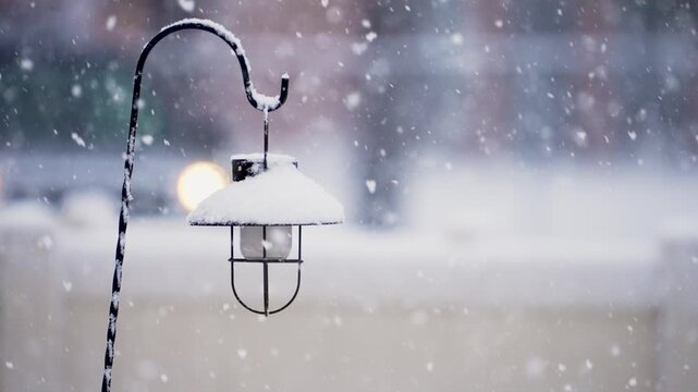 View of lamp as large snowflakes fall as car drives in the background during winter storm in Utah.