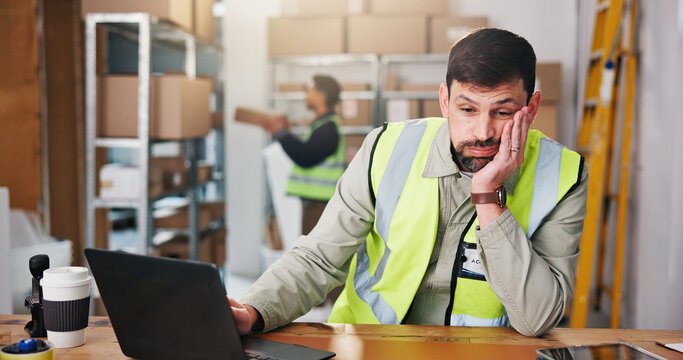 Ecommerce, think and bored man in warehouse for supply chain, distribution or planning with laptop. Computer, logistics and reflection with tired entrepreneur at work, shipping and lazy with burnout