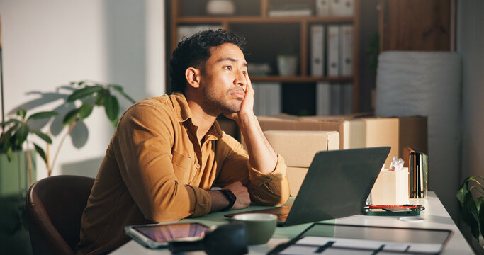 Laptop, logistics and thinking with man in office for delivery, distribution or shipping of boxes. Bored, computer and supply chain with ecommerce employee at desk in workplace for courier service