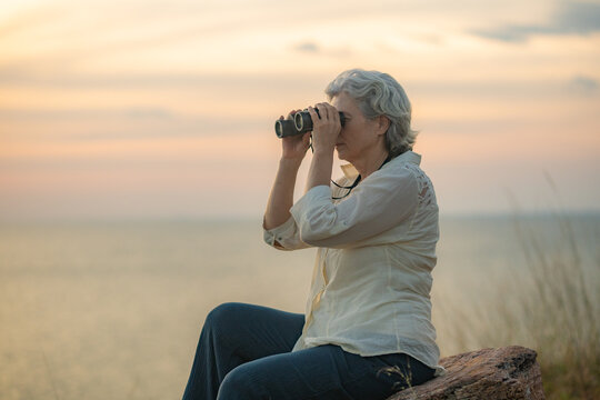 Hikers trekking through on nature trail using binoculars while the other enjoying outdoor adventure and exploration in a scenic countryside landscape representing active lifestyle and eco tourism.