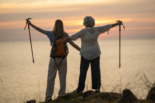 Hikers standing on rocky mountain trail resting and enjoying the scenic landscape during trekking adventure wearing backpacks and outdoor clothing representing hiking exploration and active lifestyle 
