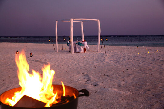 Romantic Beach Wedding Setup with Bonfire at Maldives Sunset