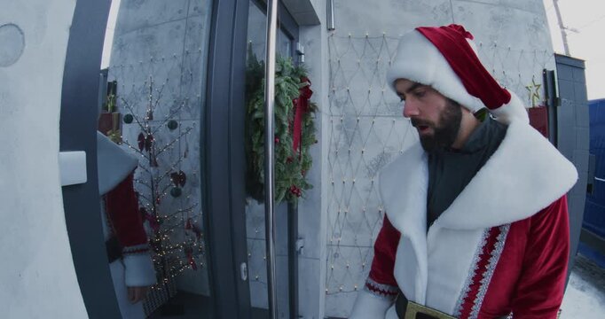 Postal Courier Dressed in Santa Costume Delivers Envelope Woman at Doorstep. Scene Captured Smart Doorbell Camera. Concept Festive Holiday Mail Delivery, Modern Mail Logistics, Cheerful Interaction.