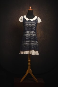 Outer black lace mini dress with white collar and beige inner in on a display mannequin