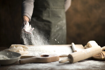 Hand Dusting Flour Over Fresh Pasta Dough in Kitchen