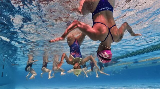 Underwater synchronized swimming duet performing elegant routine