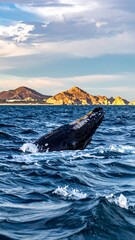 Fototapeta premium Ocean panorama with a whale breaching, distant mountains, and dramatic cloudy sky