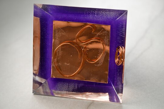 High resolution color image of a Large Handmade Orgonite Pyramid with Amethyst Crystals &ndash; Symmetrical Copper Design on White Marble Background