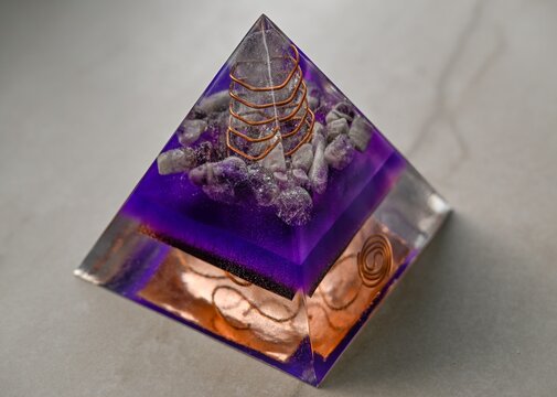 High resolution color image of a Large Handmade Orgonite Pyramid with Amethyst Crystals &ndash; Symmetrical Copper Design on White Marble Background