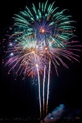 colorful fireworks bursting over a dark night sky with glowing multicolored trails, rising sparks, smoke plumes and distant city lights, creating a celebratory awe-inspiring display