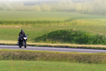 Obraz premium Person taking a peaceful motorcycle trip in summer