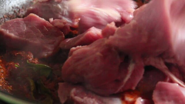 pour raw meat into the spices in the pan