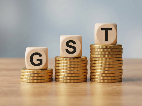gold coin stacks with wooden gst cubes representing goods and services tax payment financial planning accounting and business taxation compliance concept
