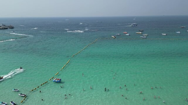 태국 파타야 산호섬의 투명한 에메랄드빛 바다와 제트스키, 바나나보트를 즐기는 역동적인 해변 휴양지 드론 항공 촬영
