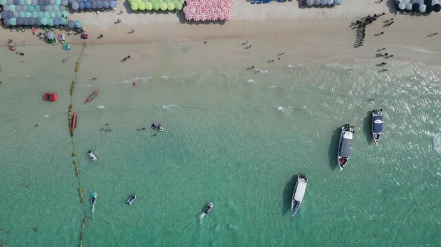 태국 파타야 산호섬의 투명한 에메랄드빛 바다와 제트스키, 바나나보트를 즐기는 역동적인 해변 휴양지 드론 항공 촬영
