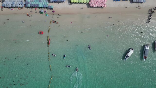태국 파타야 산호섬의 투명한 에메랄드빛 바다와 제트스키, 바나나보트를 즐기는 역동적인 해변 휴양지 드론 항공 촬영

