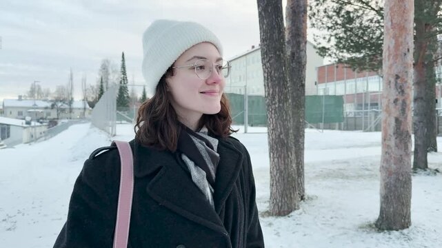 Young woman waiting the bus  on the steet at the Cold season
