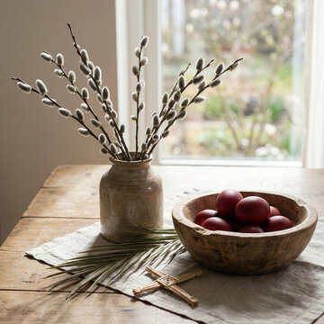 Decorative Easter table setting with red eggs and willow branches  